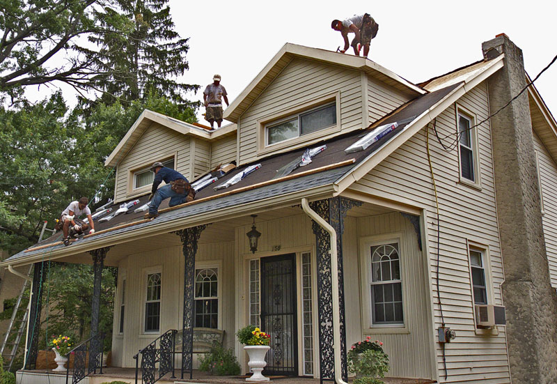 Roofers re-roofing a 2 story home